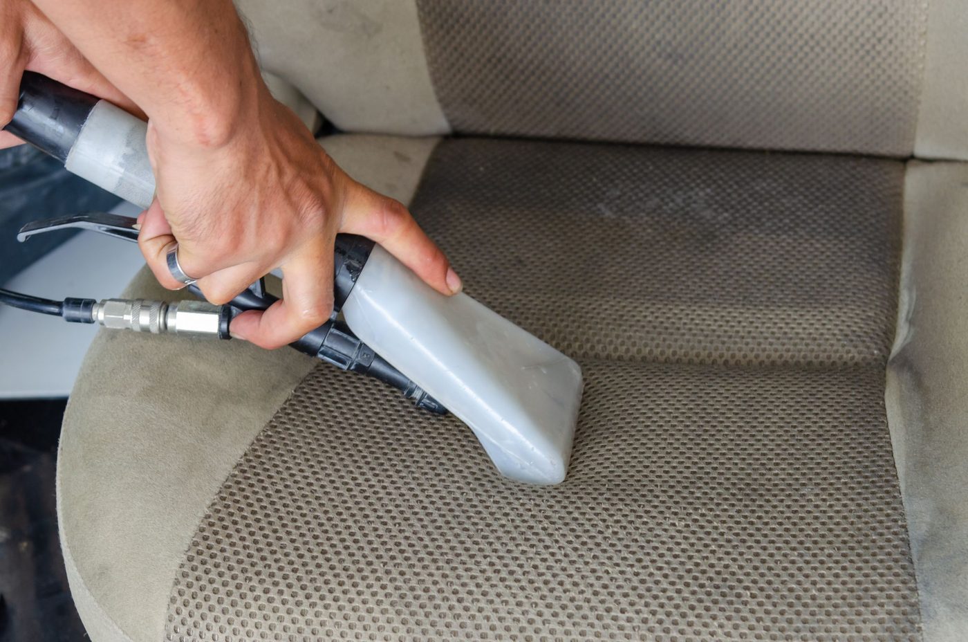 Upholstery extractor cleaning a car seat