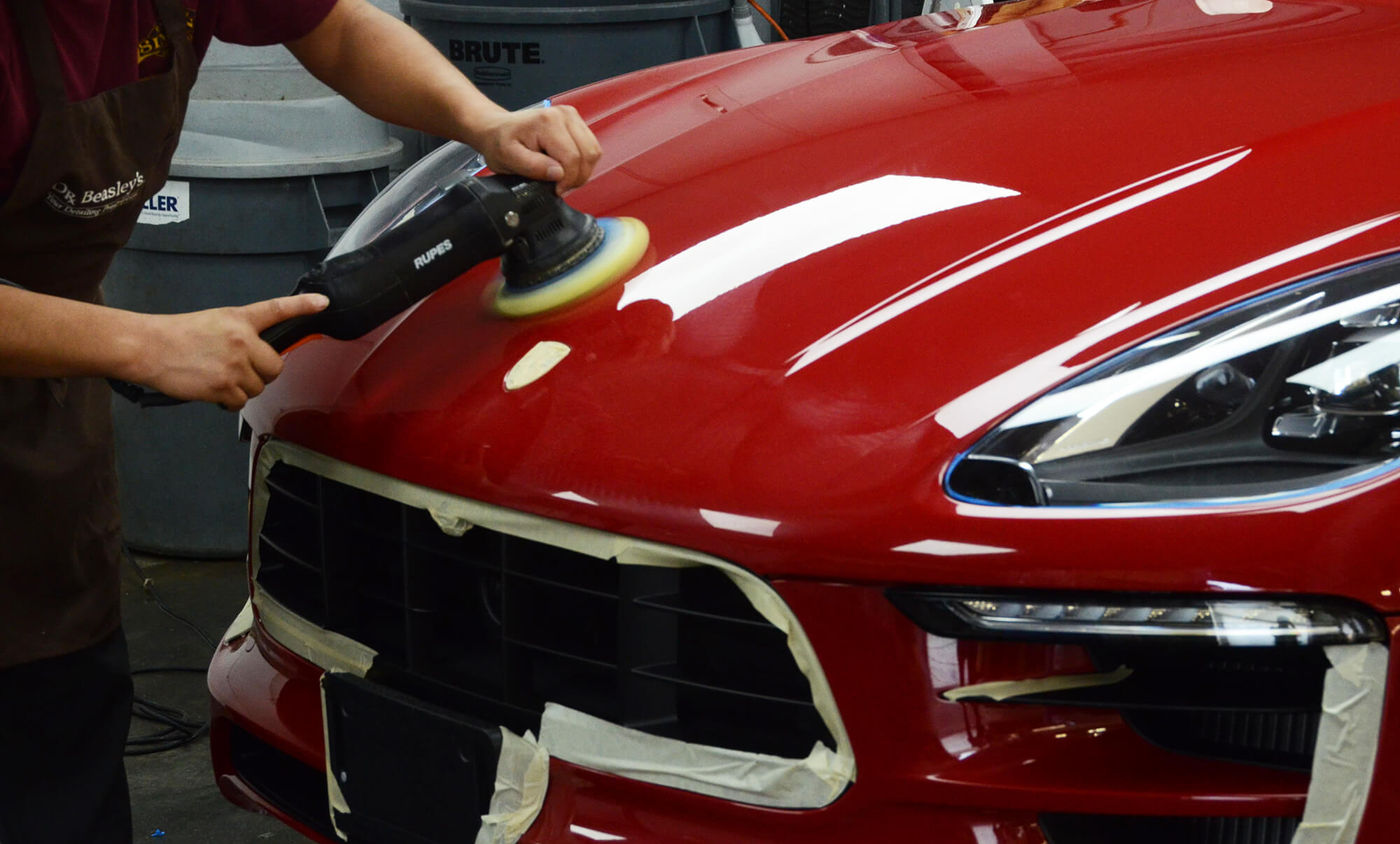 Machine polisher correcting glossy red paint